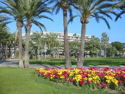 a park with palm trees and flowers in the grass at Cannes Palm Beach Parking, clim, wifi plage 2' à pieds in Cannes
