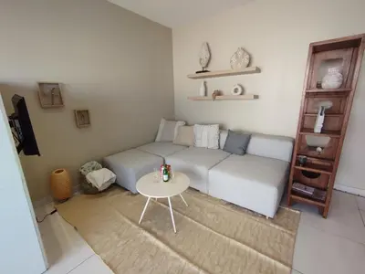 a living room with a couch and a table at Cannes Palm Beach Parking, clim, wifi plage 2' à pieds in Cannes