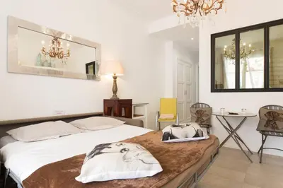 a bedroom with a bed and a table and chairs at Mythique Miramar Cannes Croisette Terrasse Clim Parking Wifi in Cannes