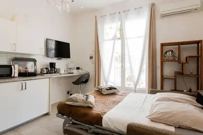 a bedroom with a large bed and a window at Mythique Miramar Cannes Croisette Terrasse Clim Parking Wifi in Cannes