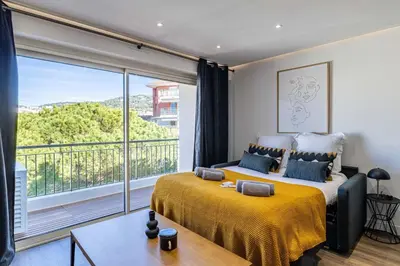 a bedroom with a bed and a large window at 8 MERLE - Beau studio au centre de Cannes avec balcon ! in Cannes