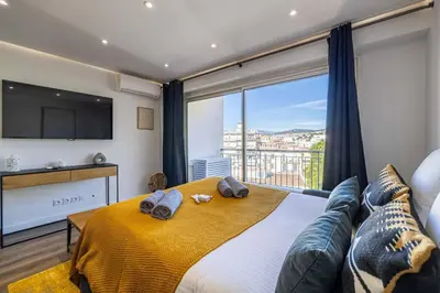 a bedroom with a large bed and a large window at 8 MERLE - Beau studio au centre de Cannes avec balcon ! in Cannes