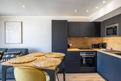 a kitchen with a table and some chairs in a room at 8 MERLE - Beau studio au centre de Cannes avec balcon ! in Cannes