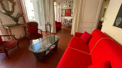 a living room with a red couch and a table at Large 2-Room Apartment Cannes - Wifi, Air Conditioning in Cannes