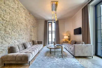 a living room with a couch and a stone wall at Marvellous 5 bed Cannes Centre in Cannes
