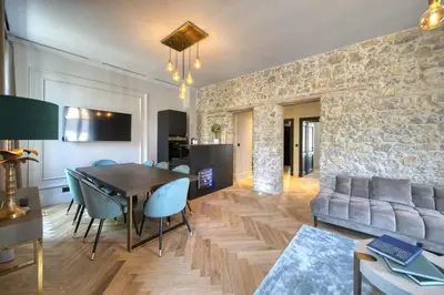 a living room with a table and a stone wall at Marvellous 5 bed Cannes Centre in Cannes