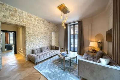a living room with couches and a stone wall at Marvellous 5 bed Cannes Centre in Cannes