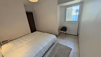 a bedroom with a bed and a chair and a window at Ref BELLAMARE in Cannes