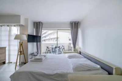 a bedroom with a large bed and a window at Magnifique studio au pied des plages in Cannes