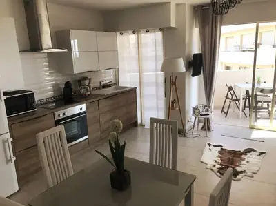 a kitchen and living room with a table and chairs at Magnifique studio au pied des plages in Cannes