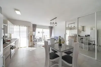 a kitchen and living room with a table and chairs at Magnifique studio au pied des plages in Cannes