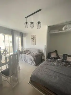 a living room with a bed and a couch at Magnifique studio au pied des plages in Cannes