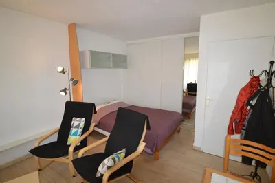 a bedroom with a bed and two chairs at Comfortable studio near the beaches in Cannes