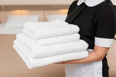 a person holding a stack of towels in a hotel room at Comfortable studio near the beaches in Cannes