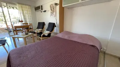 a bedroom with a bed and chairs and a table at Comfortable studio near the beaches in Cannes