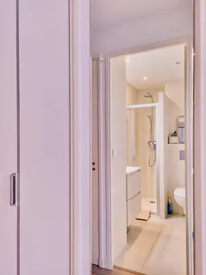 a white bathroom with a shower and a sink at Studio Latour Maubourg in Cannes