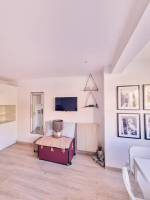 a white room with a bed and a suitcase at Studio Latour Maubourg in Cannes