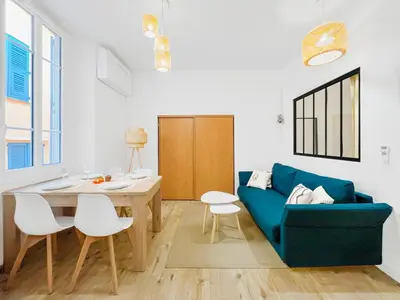 a living room with a blue couch and a table at L’Iris - Suquet Cannes Centre in Cannes