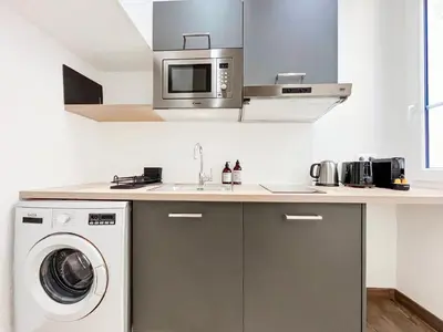 a kitchen with a washing machine and a microwave at L’Iris - Suquet Cannes Centre in Cannes