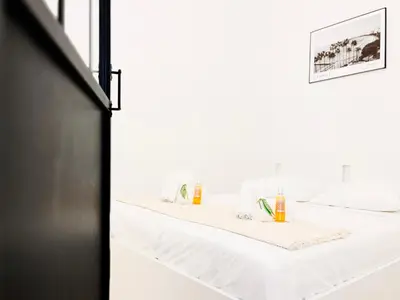 a bedroom with two beds and a mirror at L’Iris - Suquet Cannes Centre in Cannes