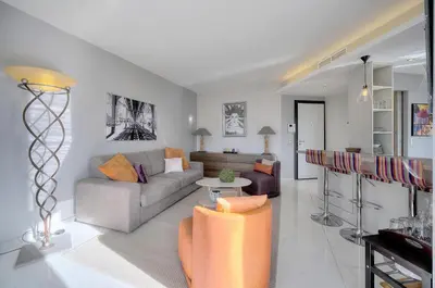 a dining room with a white table and chairs and large windows at L'Edmond - 2min Plage - VCA in Cannes