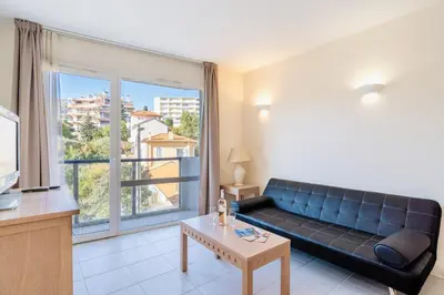 a living room with a couch and a large window at L'Excel Canne's - 3 pièces Cannes in Cannes