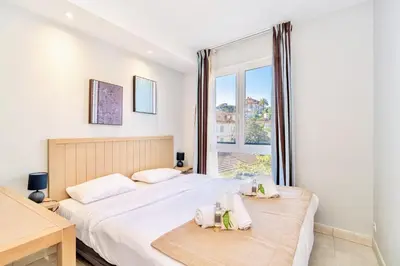 a bedroom with two beds and a window at L'Excel Canne's - 3 pièces Cannes in Cannes