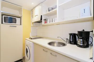 a small kitchen with a sink and a microwave at L'Excel Canne's - 3 pièces Cannes in Cannes