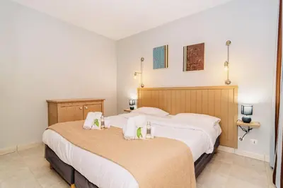 two beds in a hotel room with towels at L'Excel Canne's - 3 pièces Cannes in Cannes