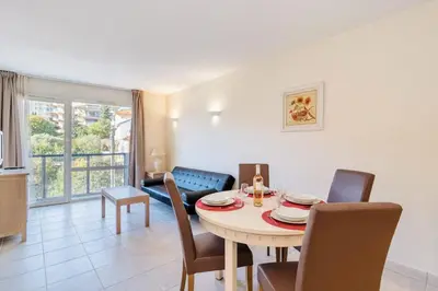 a living room with a table and a couch at L'Excel Canne's - 3 pièces Cannes in Cannes
