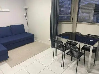 a living room with a couch and a table and chairs at Superbe Appartement avec terrasse 2 chambres, 4 à 5 couchages piscine, à deux pas des plages et de la Croisette in Cannes