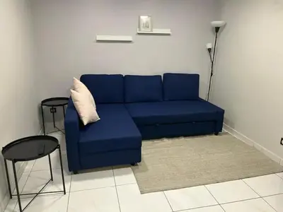 a blue couch in a living room with a table and stool at Superbe Appartement avec terrasse 2 chambres, 4 à 5 couchages piscine, à deux pas des plages et de la Croisette in Cannes