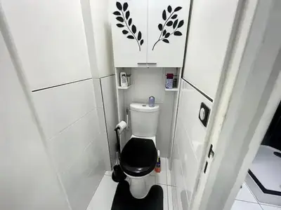 a small bathroom with a toilet with a black seat at Superbe Appartement avec terrasse 2 chambres, 4 à 5 couchages piscine, à deux pas des plages et de la Croisette in Cannes