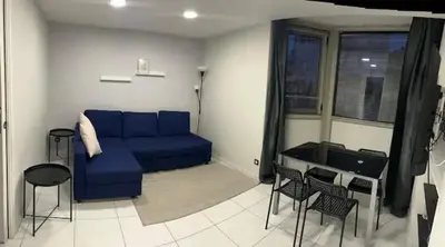 a living room with a blue couch and chairs at Superbe Appartement avec terrasse 2 chambres, 4 à 5 couchages piscine, à deux pas des plages et de la Croisette in Cannes