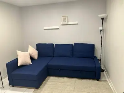 a blue couch with two pillows on it in a room at Superbe Appartement avec terrasse 2 chambres, 4 à 5 couchages piscine, à deux pas des plages et de la Croisette in Cannes