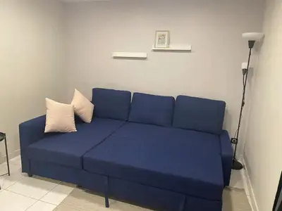a blue couch with two pillows in a living room at Superbe Appartement avec terrasse 2 chambres, 4 à 5 couchages piscine, à deux pas des plages et de la Croisette in Cannes