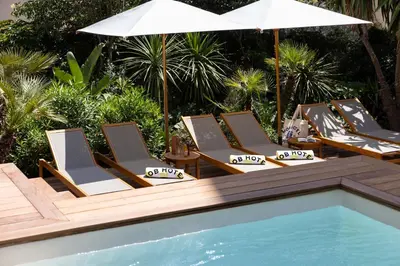 a group of lounge chairs and an umbrella next to a pool at MOB HOTEL Cannes in Cannes