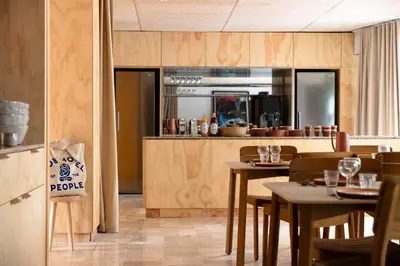 a restaurant with wooden tables and chairs and a kitchen at MOB HOTEL Cannes in Cannes