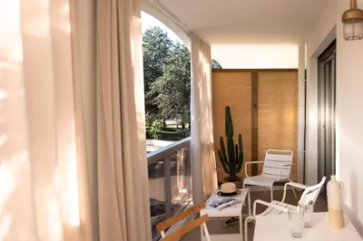 a balcony with a table and chairs and a window at MOB HOTEL Cannes in Cannes