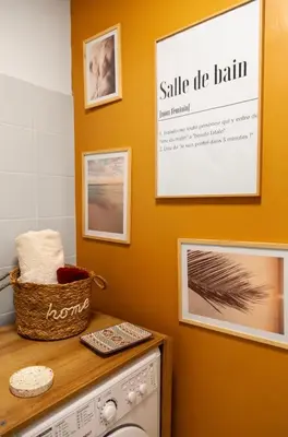 a laundry room with a washing machine and pictures on the wall at Studio lumineux à 2 mn à pied de la plage in Cannes
