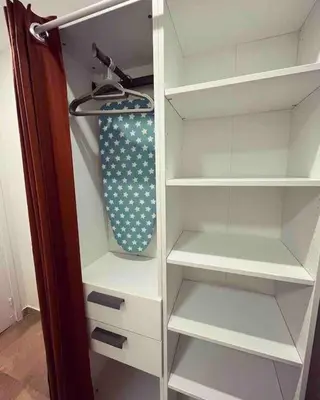 a closet with white shelves and a tie in it at Studio lumineux à 2 mn à pied de la plage in Cannes