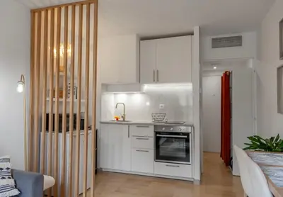 a kitchen with white cabinets and a stove at Studio lumineux à 2 mn à pied de la plage in Cannes