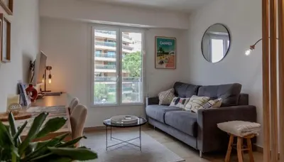 a living room with a couch and a table at Studio lumineux à 2 mn à pied de la plage in Cannes