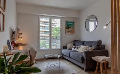 a living room with a couch and a table at Studio lumineux à 2 mn à pied de la plage in Cannes