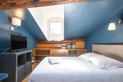 a blue bedroom with a bed and a television at Triplex 150m2 coeur vieille ville in Cannes