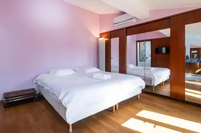 a bedroom with two beds and a mirror at Triplex 150m2 coeur vieille ville in Cannes