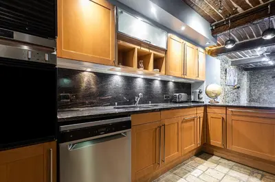 a kitchen with wooden cabinets and stainless steel appliances at Triplex 150m2 coeur vieille ville in Cannes