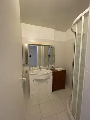a white bathroom with a sink and a shower at GuestRoom - Chambre d'hôte in Le Cannet