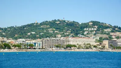 a view of a beach with buildings and a mountain at GuestRoom - Chambre d'hôte in Le Cannet