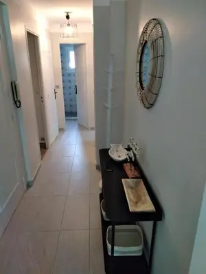 a hallway with a table and a mirror on a wall at Le jasmin du Riou in Cannes